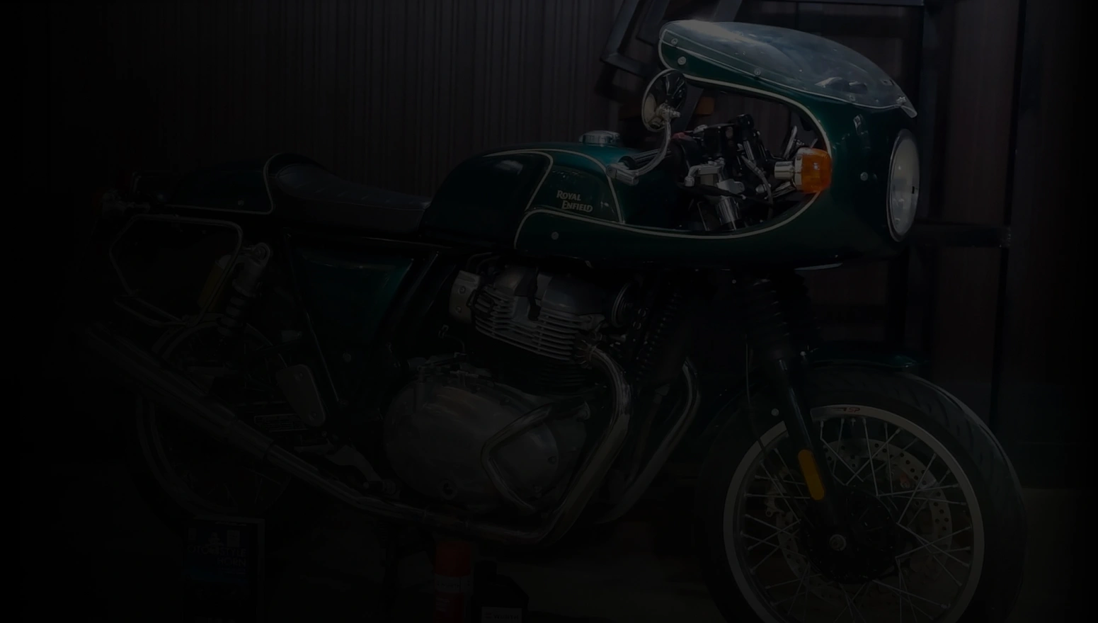 A Green Royal Enfield café racer displayed under soft lighting